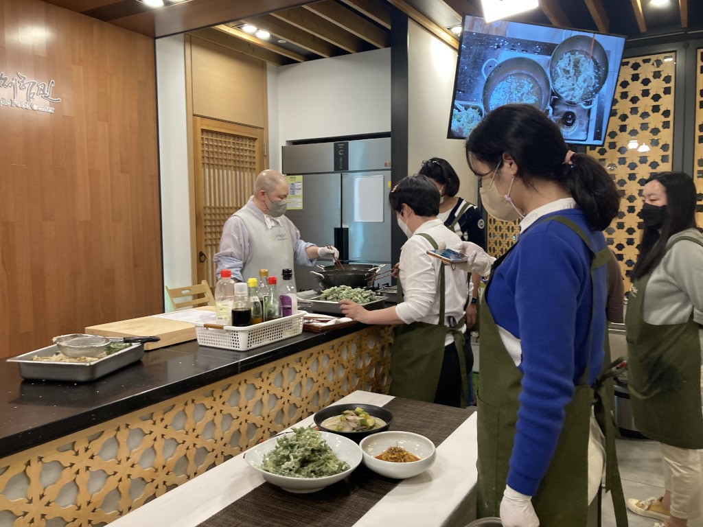 Seonggeon Sunim helping students frying greens